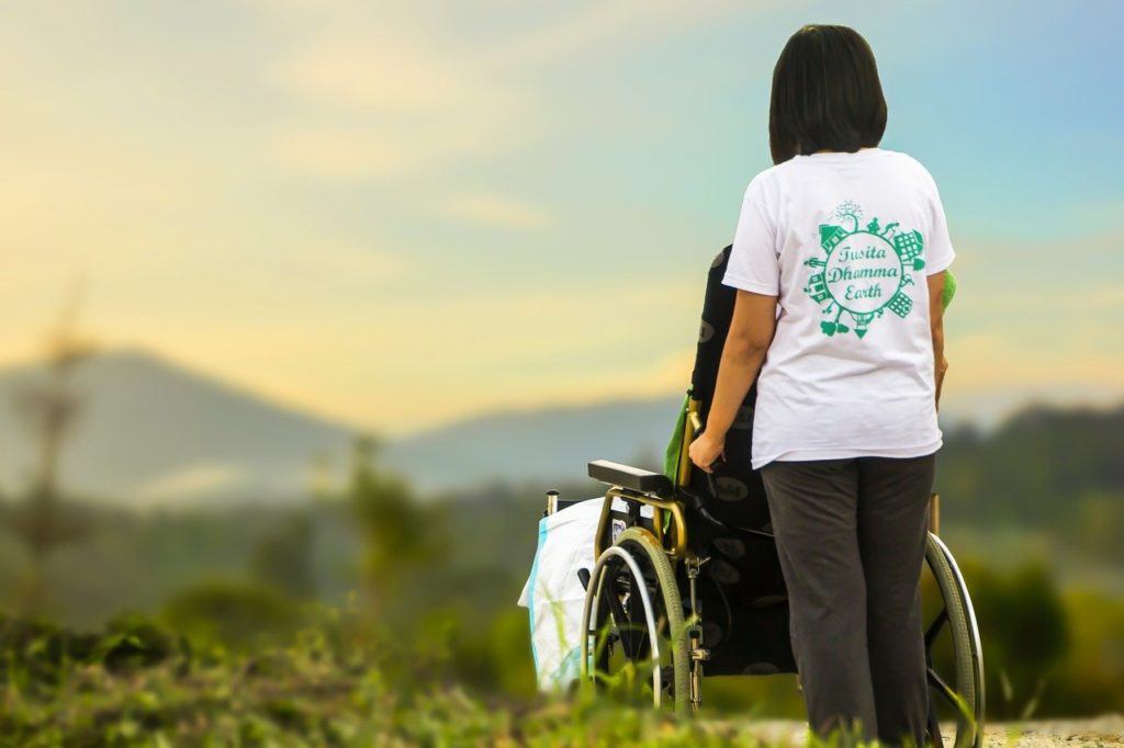 Pflegerin mit Rollstuhlpatient